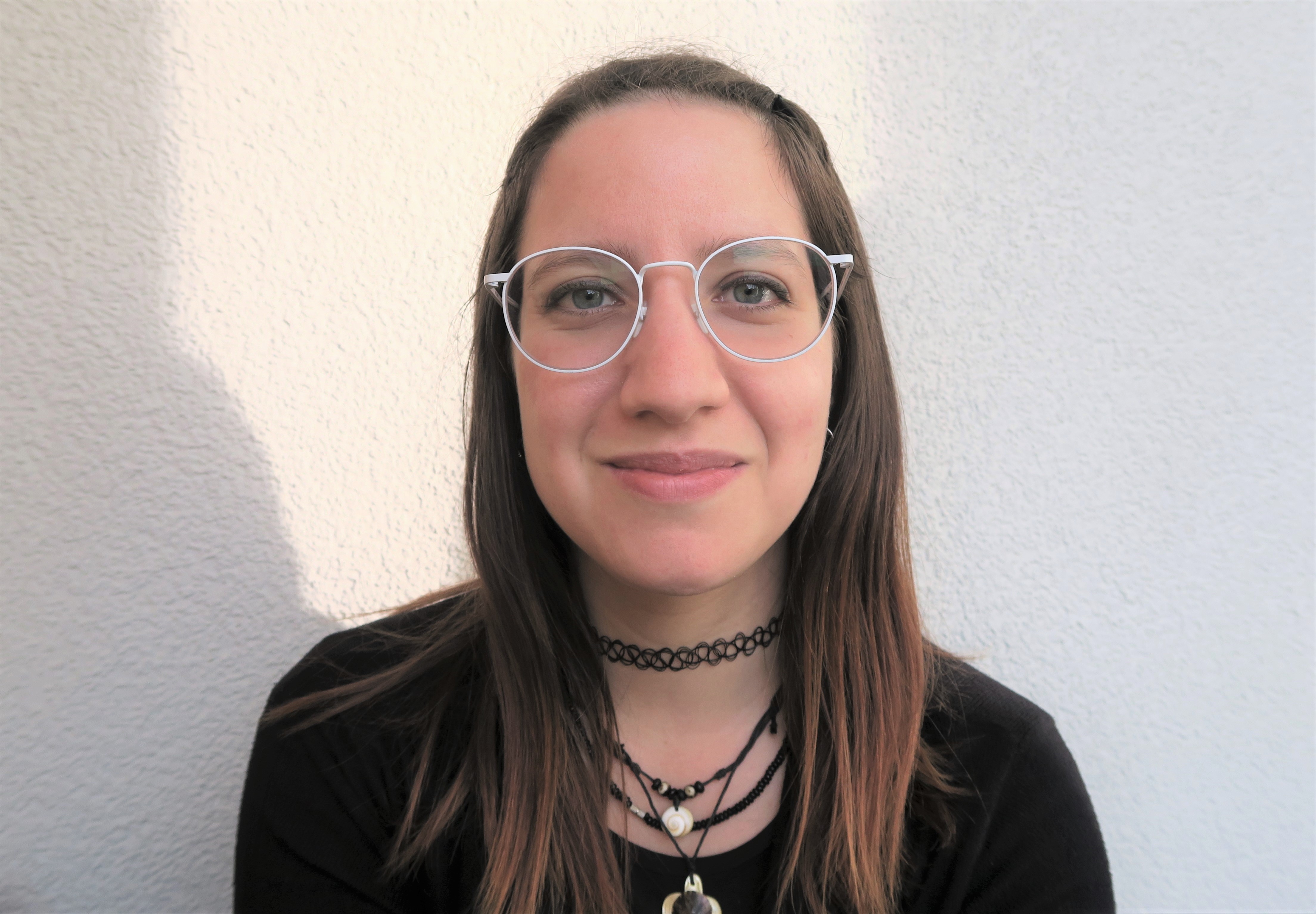 Headshot of Marta Cortesão in a black shirt wearing glasses.