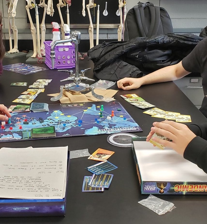 board game Pandemic on lab bench with anatomy skeletons in background